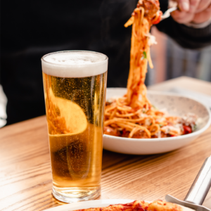Image shows Bella Italia pasta dish and pint of beer